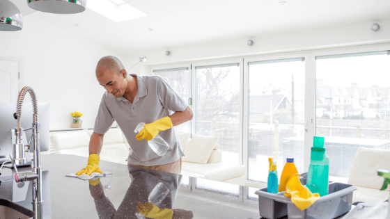 man-spraying-kitchen-countertop-spring-cleaning